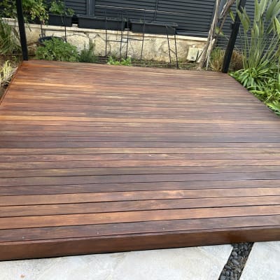 דק עץ בגינה עם צמחייה מסביב