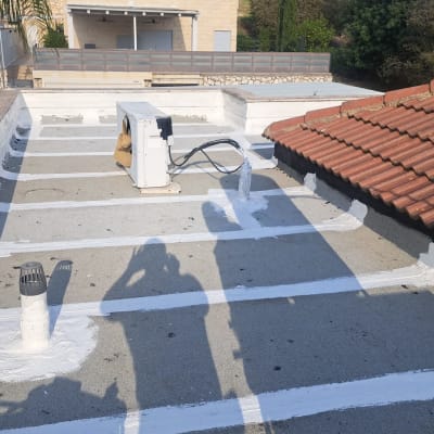 גג עם איטום לבן ומזגן על הגג