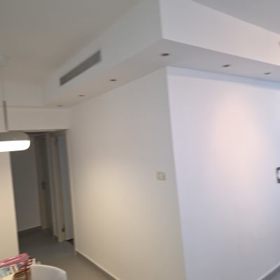 קירות צבועים בלבן עם תקרה מעוצבת ותאורה