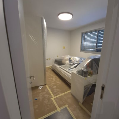 חדר עם רהיטים מכוסים בניילון לקראת צביעה