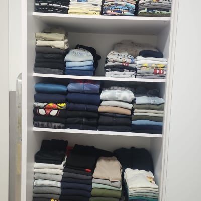 ארון בגדים מסודר עם בגדים מקופלים ונעליים