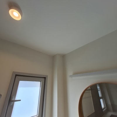 תקרה צבועה עם חלון ומראה עגולה