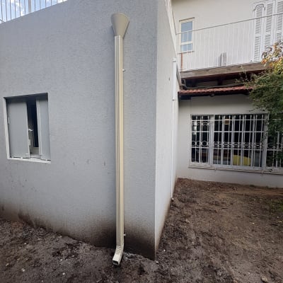 מרזב מחובר לגג שטוח עם מעקה מתכת