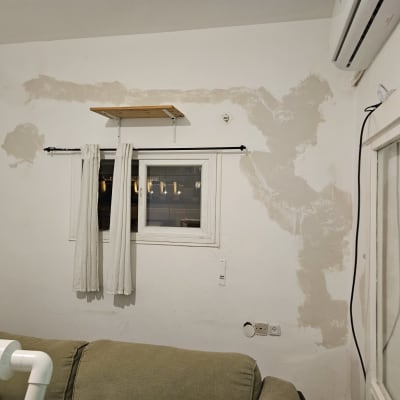 חלון עם וילון לבן על מוט שחור