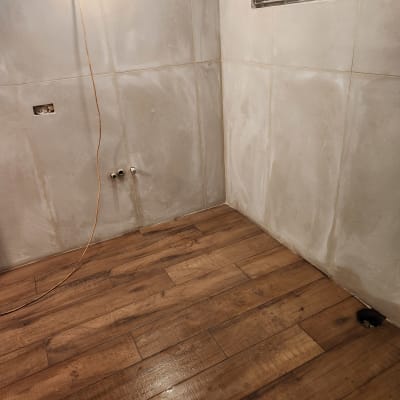 חדר עם רצפת עץ חדשה וקירות עם חיפוי קרמיקה