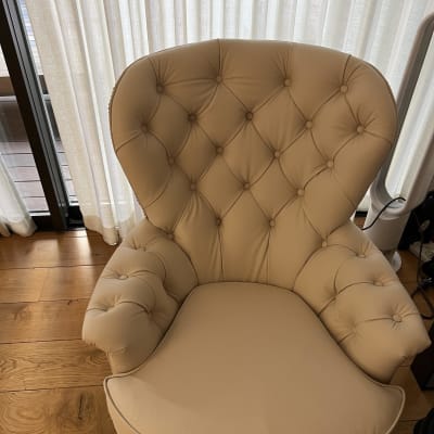 כורסה מרופדת עם כפתורים על משענת וידיות