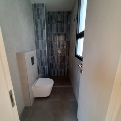 חדר אמבטיה עם שירותים ומקלחת, אריחים אפורים