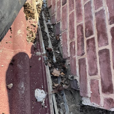 גג רעפים אדומים עם עלים ולכלוך בין הרעפים