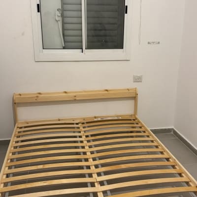 מיטה מעץ עם שלבי עץ בחדר שינה