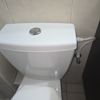 אסלה לבנה עם צינור חיבור לקיר