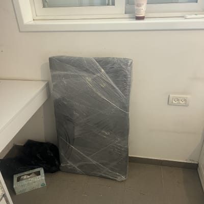 חפץ עטוף בניילון מונח על הרצפה ליד חלון