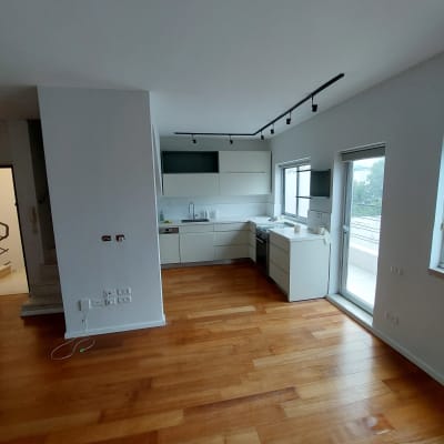 מטבח מודרני עם ארונות לבנים ותאורה שחורה