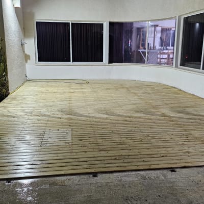 דק עץ מותקן בחצר עם קקטוסים מסביב