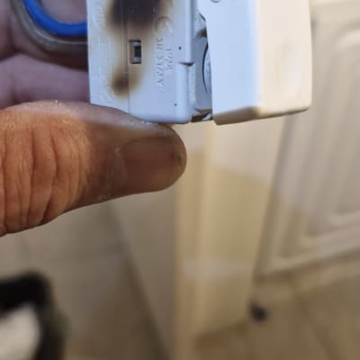 תקע חשמלי מוחזק ביד עם סימני שריפה