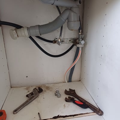 כלים וצנרת מתחת לכיור במטבח