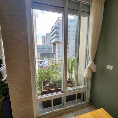 חלון אלומיניום עם מסגרת לבנה ותריסים