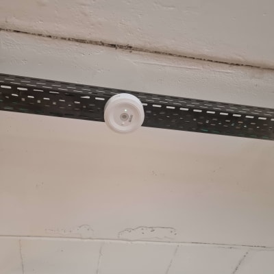 חיישן עגול מותקן על תקרה עם מסילה שחורה