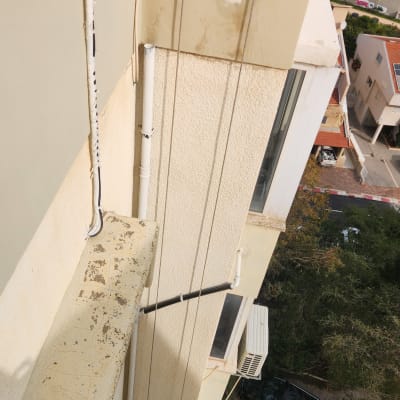 עבודות בגובה על בניין עם חבלים וציוד בטיחות