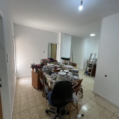 חדר עם שולחן מלא כלים וסולם ברקע