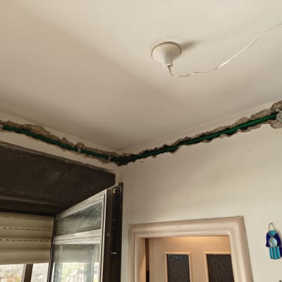 תעלה בקיר עם צינור חשמל ירוק