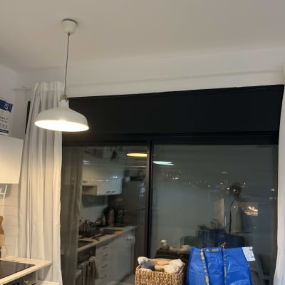 מנורה תלויה מעל מטבח עם וילון לבן