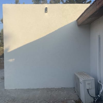 קיר לבן עם מזגן חיצוני ותאורה עליונה