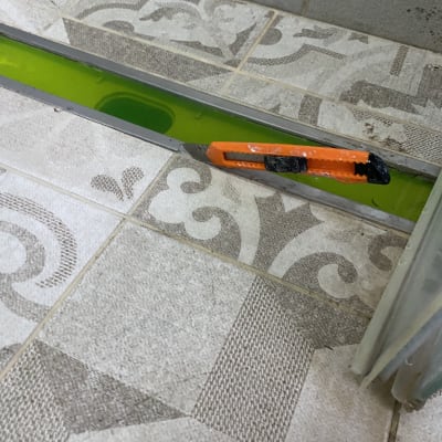 סכין יפנית כתומה בתעלת ניקוז עם נוזל ירוק