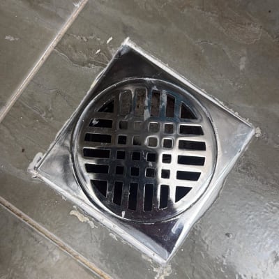 ניקוז מתכת על רצפת אריחים אפורה