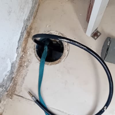 צינור וכלי עבודה ליד קיר עם חור ברצפה