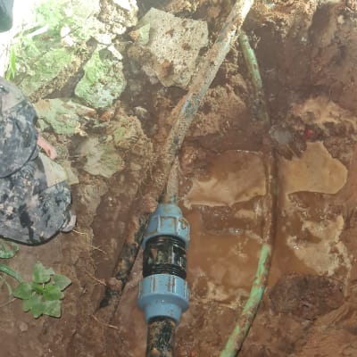 תיקון צינור מים באדמה עם מחבר כחול