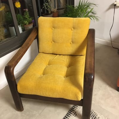 כורסה צהובה עם ריפוד מרופד וכפתורים