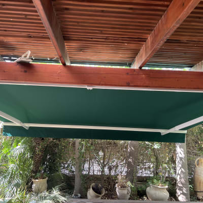 סוכך ירוק מתחת לגג עץ עם קורות עץ חשופות