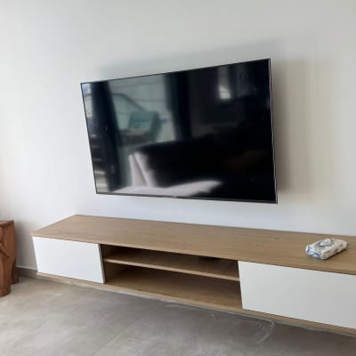 טלוויזיה מותקנת על קיר עם שידה מתחת