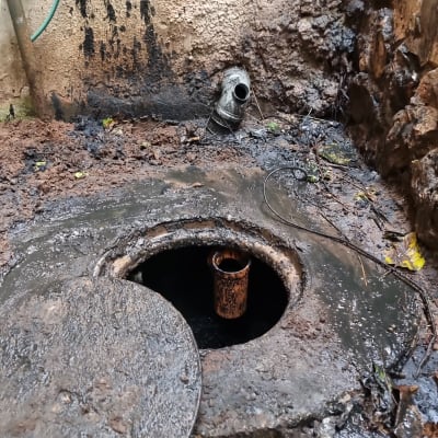 פתח ביוב עם מכסה פתוח וצינור מתכת