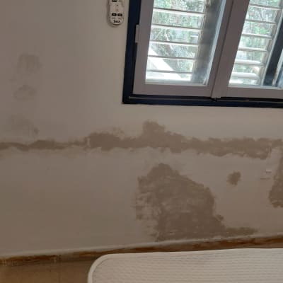 קיר עם סימני תיקון ליד חלון