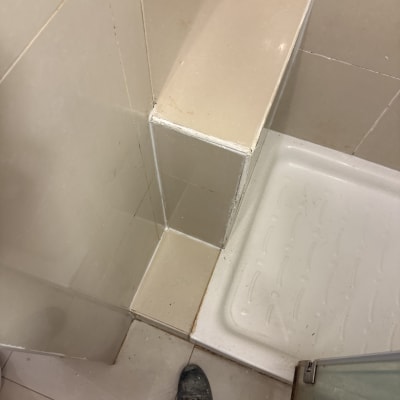 מקלחת עם אריחים ורגל של עובד