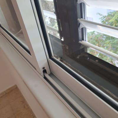חלון עם מסגרת מתכתית ותריסים לניקוי