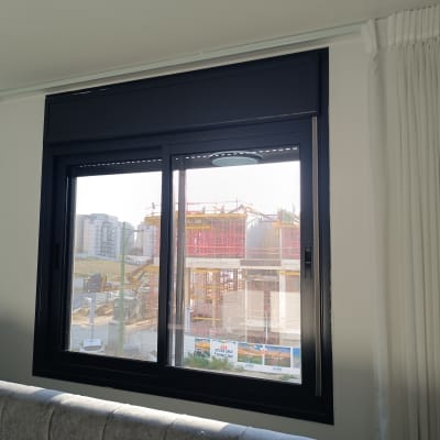 חלון עם תריסים נראים בבניין מגורים