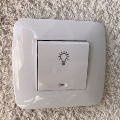 מתג חשמל עם סמל נורה על קיר