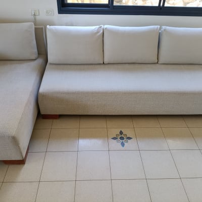 ספה בהירה על רצפת אריחים עם עיטור