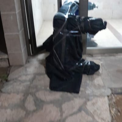 חפץ עטוף בניילון שחור ליד דלת זכוכית