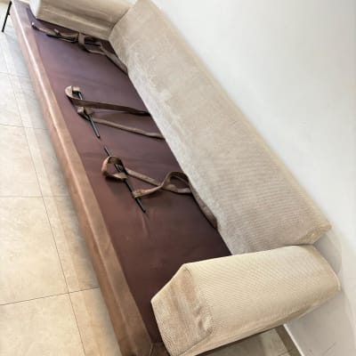 ספה מפורקת עם רצועות חומות על רצפה בהירה