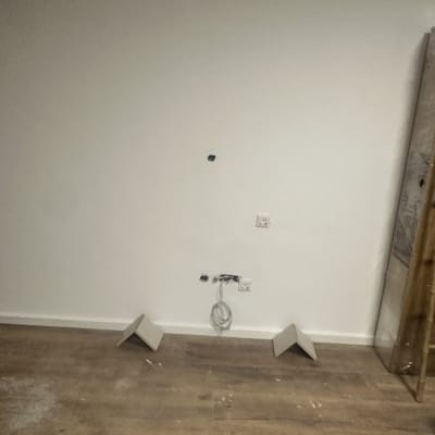 קיר עם חיבורים חשמליים ורצפת עץ