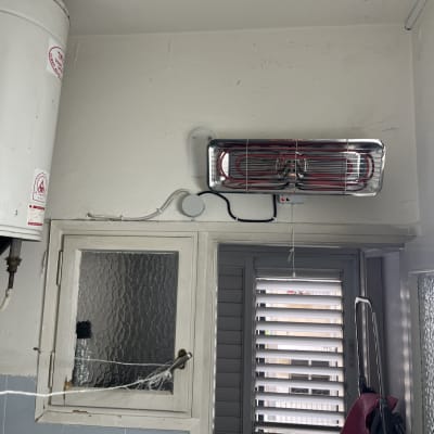 תנור חימום חשמלי מותקן על קיר עם חוטי חשמל