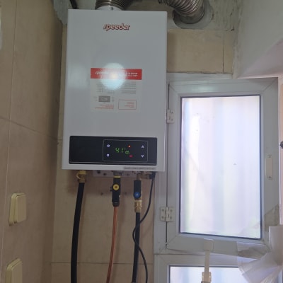 דוד גז מותקן על קיר עם צינורות חיבור