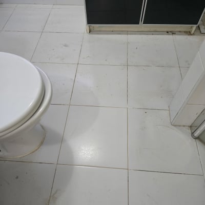 רצפת חדר אמבטיה עם אריחים לבנים ושירותים