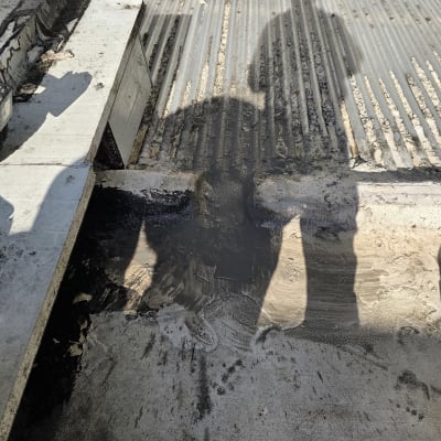 צל של אדם על משטח עם חומר איטום שחור