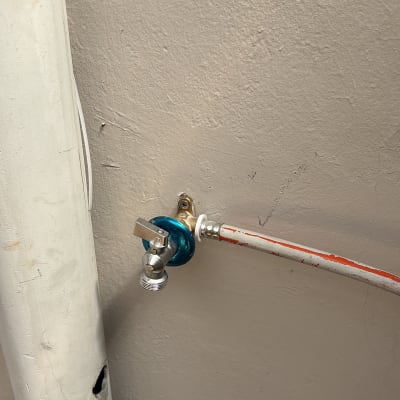 ברז מים מחובר לצינור על קיר