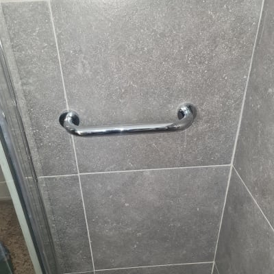 ידית מתכת על קיר אריחים אפור