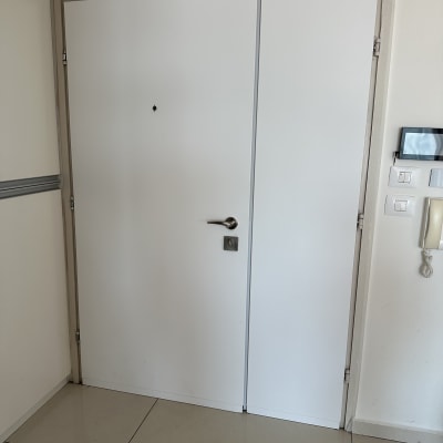 דלת לבנה עם ידית מתכת ומנעול